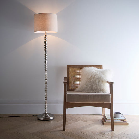 Floor Lamp in a Ribbed Satin Nickel finish on a tall candlestick design base with a Natural Linen Lampshade