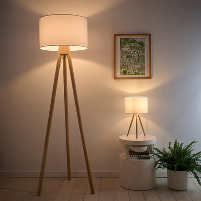 Oak tripod floor lamp and matching table lamp with white linen shades in styled living room